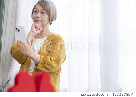 Senior woman using a matching app on her smartphone Senior woman using a matching app on her smartphone 133357897