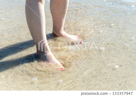 Young woman walking on the seashore, white waves, clear skies, seaside, bare feet, beautiful, ideal, holiday, vacation, beach, woman Young woman walking on the seashore, white waves, clear skies, seaside, bare feet, beautiful, ideal, holiday, vacation, beach, woman 133357947