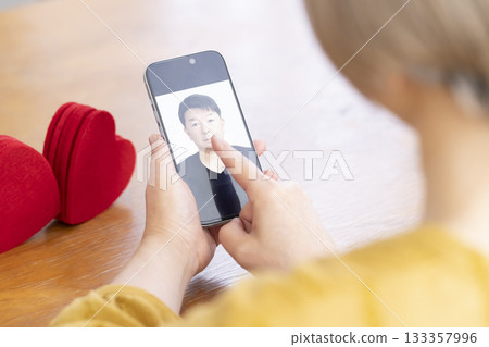 Senior woman using a matching app on her smartphone Senior woman using a matching app on her smartphone 133357996