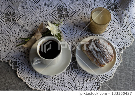 Coffee and brioche served on a romantic tablecloth with a bouquet of white flowers symbolising the celebration. Ideal for Valentine's Day, Mother's Day Coffee and brioche served on a romantic tablecloth with a bouquet of white flowers symbolising the celebration. Ideal for Valentine's Day, Mother's Day 133360427