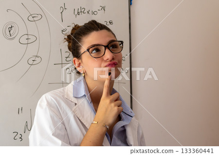 Woman teacher thinking about complex formulas and atomic structures on a whiteboard, problem solving in science education, contemplating a challenging question 133360441
