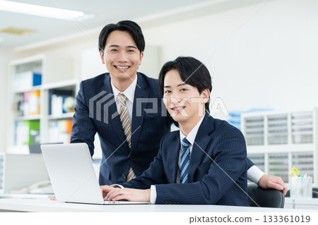 工作在辦公室的一個年輕商人 工作在辦公室的一個年輕商人 133361019