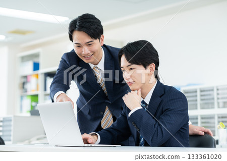工作在辦公室的一個年輕商人 工作在辦公室的一個年輕商人 133361020