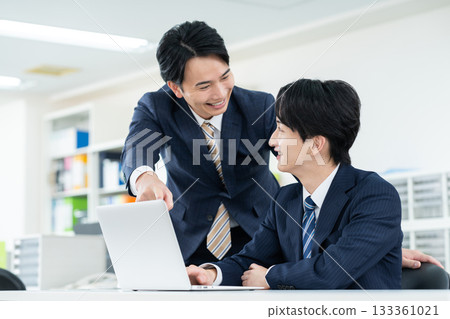 工作在辦公室的一個年輕商人 工作在辦公室的一個年輕商人 133361021