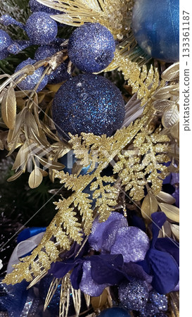 Luxury gold and glittering blue Christmas ornaments on a festive evergreen branch Luxury gold and glittering blue Christmas ornaments on a festive evergreen branch 133361187
