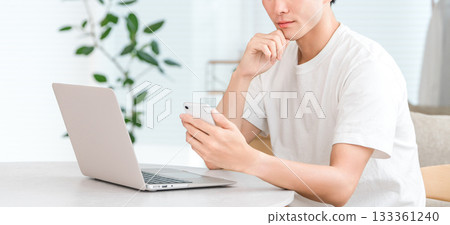 Young Asian man using a computer and smartphone (investment, money literacy, asset formation, asset management) Young Asian man using a computer and smartphone (investment, money literacy, asset formation, asset management) 133361240