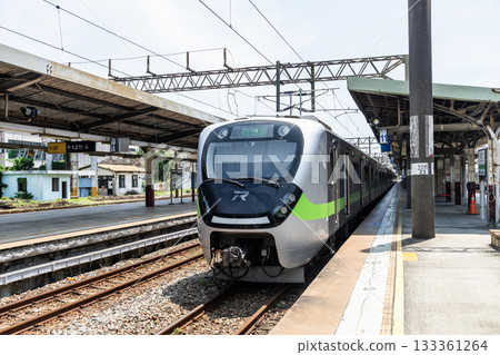 A local train (EMU900 series) is stopped on the platform of the Hsinchu Railway Station. It was the oldest station in Taiwan, now listed as a national monument. 133361264