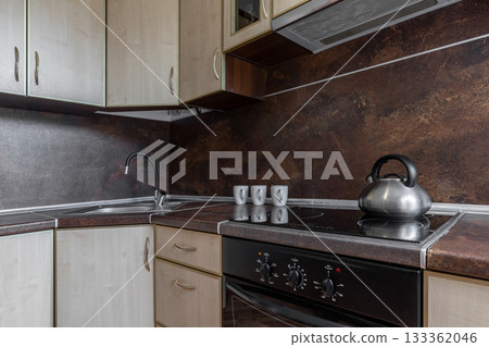 Modern Kitchen Interior with Electric Stove and Metal Kettle 133362046