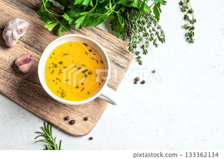Beef bone broth with herbs in mug 133362134