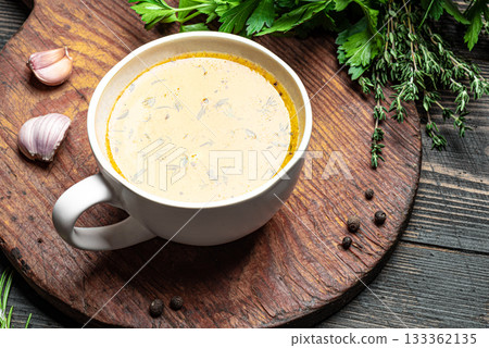 Beef bone broth with herbs in mug 133362135