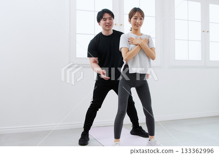 Young woman receiving training from a personal trainer 133362996