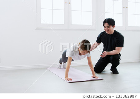 年輕女子正在接受私人教練的訓練 年輕女子正在接受私人教練的訓練 133362997