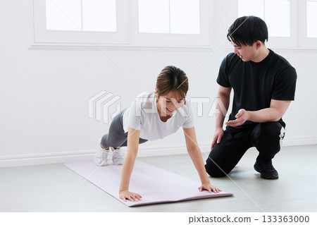 Young woman receiving training from a personal trainer Young woman receiving training from a personal trainer 133363000