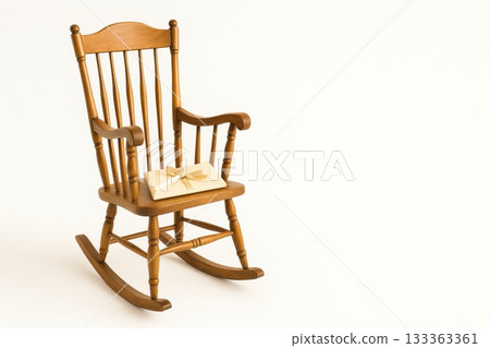 Wooden rocking chair with wrapped gift on white background Wooden rocking chair with wrapped gift on white background 133363361