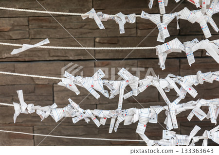 Close-up shots capture traditional white paper slips carrying wishes, tied to ropes. 133363643