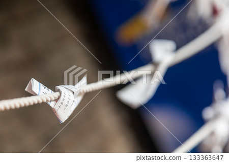 特寫捕捉繫在繩索上乘載願望的傳統白色紙籤 133363647
