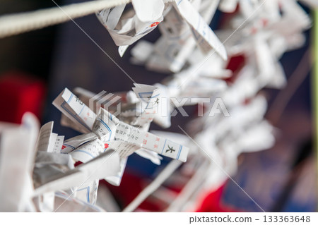 Close-up shots capture traditional white paper slips carrying wishes, tied to ropes. Close-up shots capture traditional white paper slips carrying wishes, tied to ropes. 133363648