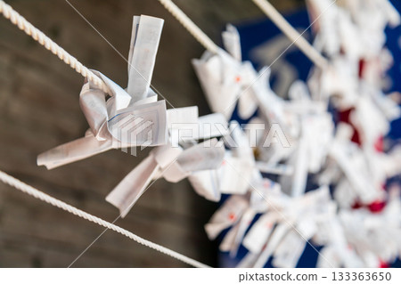 特寫捕捉繫在繩索上乘載願望的傳統白色紙籤 特寫捕捉繫在繩索上乘載願望的傳統白色紙籤 133363650