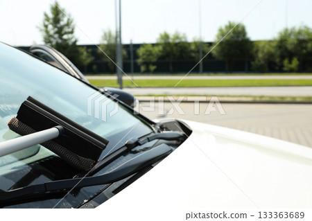 Refueling occurs while cleaning the windshield of a vehicle Refueling occurs while cleaning the windshield of a vehicle 133363689