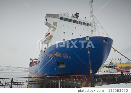 Large cargo ship in the port against the background of a gray sky in winter Large cargo ship in the port against the background of a gray sky in winter 133363920