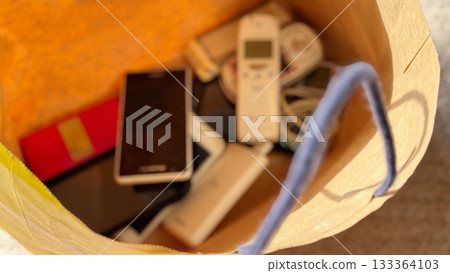 紙袋裡裝著許多智慧型手機和行動電話（模糊處理） 133364103