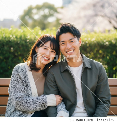 A friendly couple sitting on a park bench A friendly couple sitting on a park bench 133364170