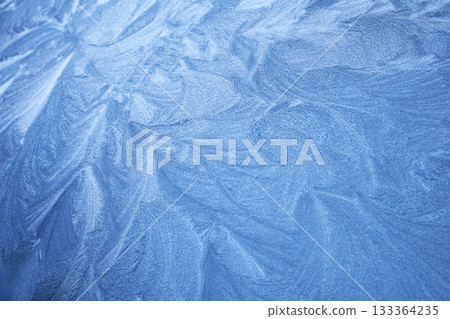 Frosty Patterns. Close-up of intricate frost designs on a blue surface, 133364235