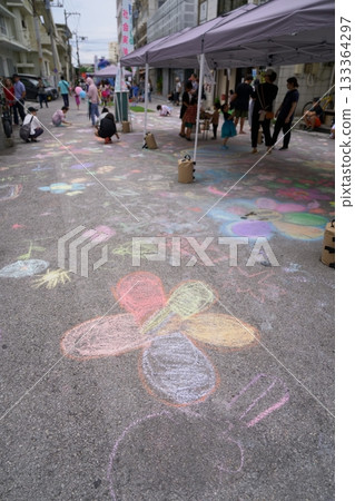 Ishigaki Island Festival: Children drawing colorful chalk art on the road (event scene) 133364297