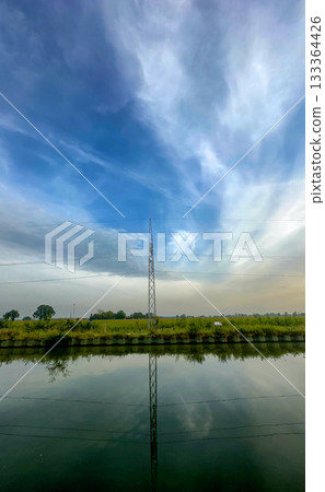 Serene water reflection beneath stylish cirrus and soft sky 133364426