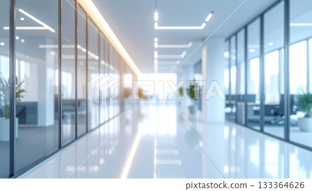 The long glass hallway of a modern office building interior is empty, showing bright light through the window and an architectural design 133364626