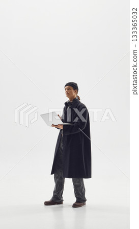 Stylish man in long coat using laptop symbolizing modern creative work and urban fashion confidence Stylish man in long coat using laptop symbolizing modern creative work and urban fashion confidence 133365032
