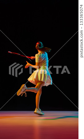 Female tennis player finishing swing in graceful motion illuminated by colorful light Female tennis player finishing swing in graceful motion illuminated by colorful light 133365074