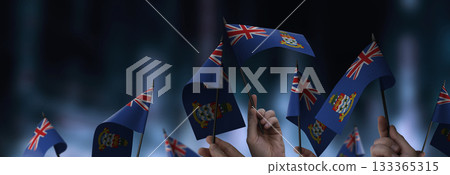 Cayman Islands flags in their hands on a blurred urban background 133365315