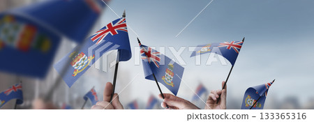 Cayman Islands flags in their hands on a blurred urban background Cayman Islands flags in their hands on a blurred urban background 133365316