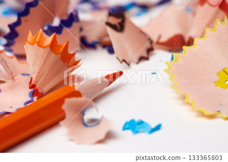 Orange pencil tip surrounded by colorful wood shavings on a white background 133365803