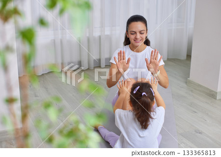 Mother and daughter bonding through playful fitness activity at home 133365813