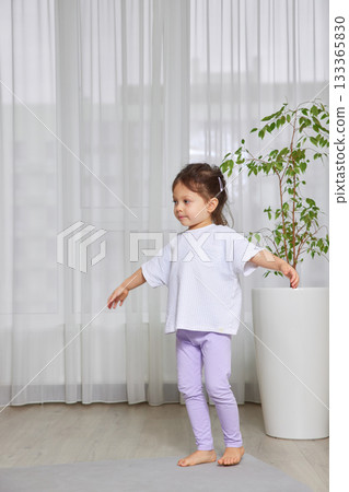 Little girl practicing exercise for healthy lifestyle and physical development 133365830