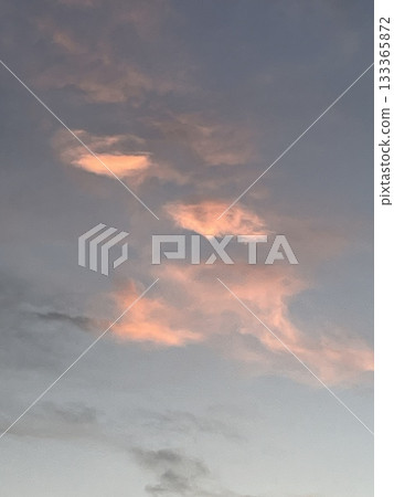 夕陽西下，雲朵被照亮，形成一種偶然的形狀。 133365872