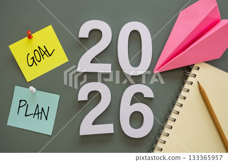 number of New Year 2026 with word goal and plan on post-it paper pin on green background, notebook, and paper plane symbolize New Year targets, resolutions, strategy, progress, and fresh starts. number of New Year 2026 with word goal and plan on post-it paper pin on green background, notebook, and paper plane symbolize New Year targets, resolutions, strategy, progress, and fresh starts. 133365957