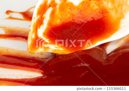 Ketchup is in a cup tomato splash isolated on white background Ketchup is in a cup tomato splash isolated on white background 133366011