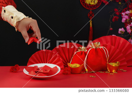 Lunar New Year tradition. Hand placing red envelope on festive table. 133366080