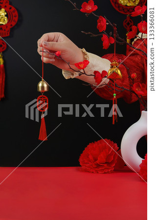Lunar New Year charm. Hand holding decorative bell with red tassel. Lunar New Year charm. Hand holding decorative bell with red tassel. 133366081