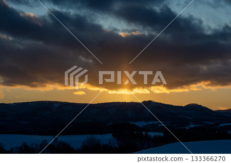 Sun pillar extending from the mountain in winter 133366270