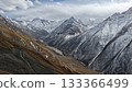 Majestic snow-capped mountains with valley and river under cloudy sky 133366499