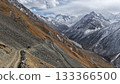 Majestic mountain landscape with winding road and snow-capped peaks 133366500