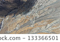 Aerial view of winding mountain road through rocky terrain and valleys 133366501