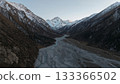 Majestic snow-capped mountains towering over winding river valley landscape 133366502