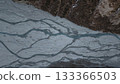 Aerial view of winding river flowing through rocky terrain and forest 133366503