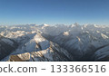 Snow-covered mountain peaks under clear blue sky with distant ranges 133366516