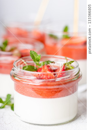 Panna cotta in glass jar with strawberry sauce and mint leaf. Panna cotta in glass jar with strawberry sauce and mint leaf. 133366805